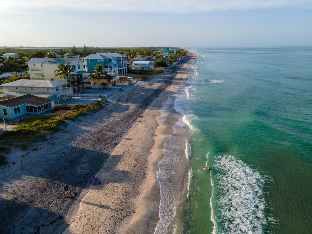 Stunning aerial view of the coastline in Englewood, FL with waves and beachfront houses.