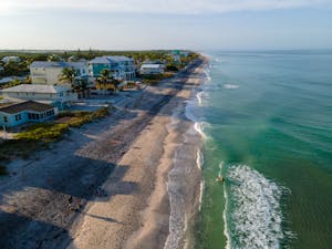 Stunning aerial view of the coastline in Englewood, FL with waves and beachfront houses.