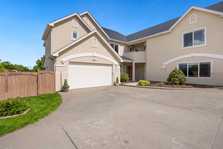 Spacious modern suburban home exterior with a double garage entrance and landscaped front yard.