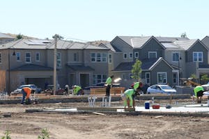 Construction workers laying foundations in a modern housing development.