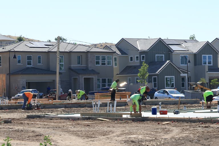 Construction workers laying foundations in a modern housing development.