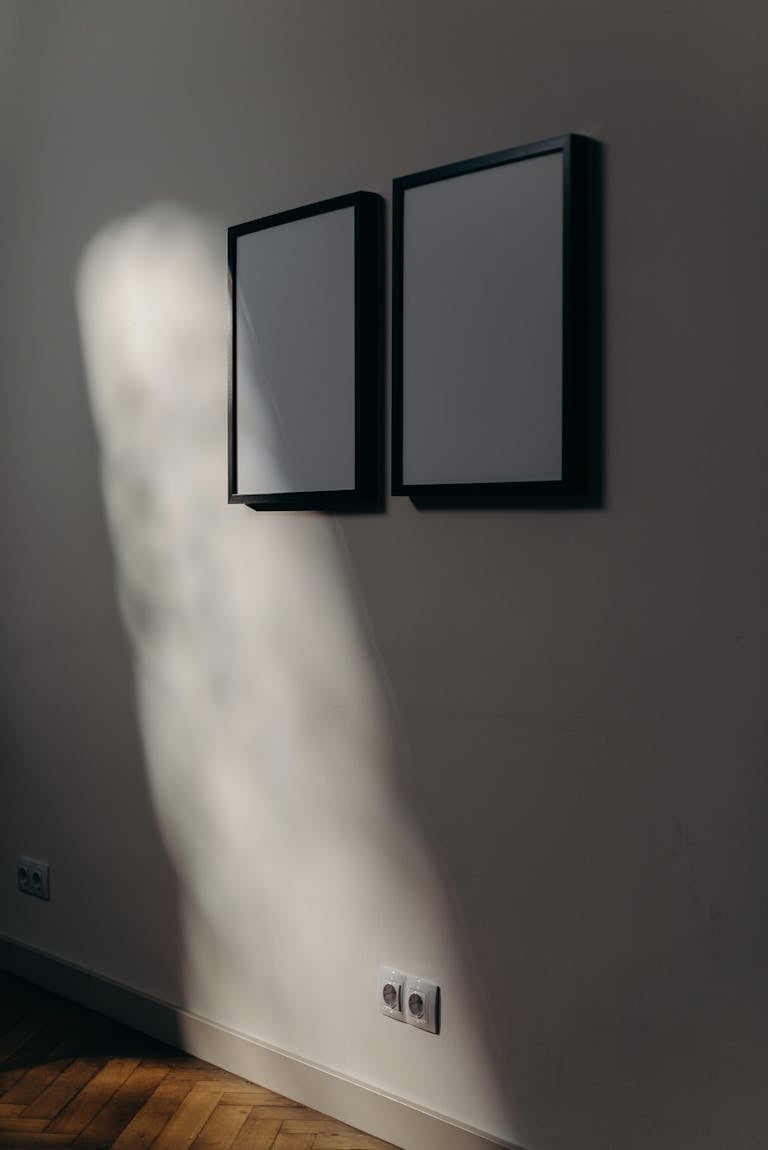 Minimalist contemporary art wall with framed poster artworks in modern interior design setting.